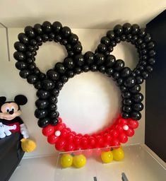 a mickey mouse balloon sculpture in the shape of a heart