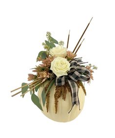 a white pumpkin decorated with flowers and greenery