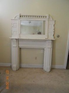 an empty living room with a fireplace and mirror