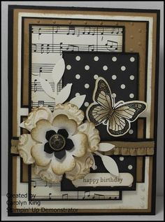 a close up of a card with a flower and butterfly on the front, and music notes in the background