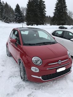 two cars parked in the snow next to each other