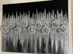 a black and white painting with roses on it's side in front of a wall