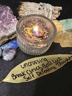 a candle sitting on top of a table next to some rocks and other things that are around it