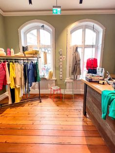 the inside of a clothing store with wooden floors