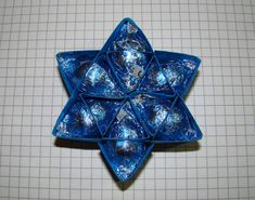 an origami star with blue foil wrapped around it