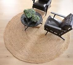 two chairs and a coffee table on a rug in a living room with hardwood floors