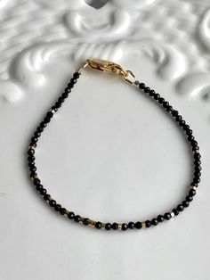 "14 k gold filled 2.3mm micro black spinel bracelet, 14k Gold Filled clasp, crimp and 14k GF gold beads. 7 1/2\"or custom size The black spinel beads are new. The 14k Gold Filled clasp and beads are new and made in the USA. The 12K gold heart is three colors of gold and stamped 12k on the back. I can custom size this at no extra charge" Minimalist Black Jewelry With Gold Beads, Minimalist Black Beaded Bracelets With Faceted Beads, Dainty Black Beaded Bracelets With Tiny Beads, Black Faceted Bead Bracelets For Everyday, Black Beaded Bracelets With Faceted Beads, Everyday Black Beaded Bracelets With Faceted Beads, Everyday Black Faceted Beaded Bracelets, Everyday Black Faceted Beads Bracelet, Black Spinel Bracelet