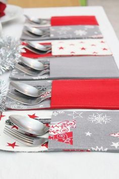 a table with silverware and red napkins sitting on top of it next to christmas decorations