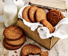 some cookies are in a wooden box next to a bottle of milk and a glass of milk