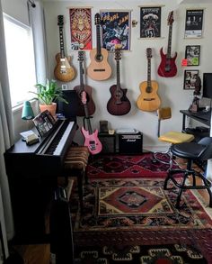 a living room with guitars on the wall and a piano in front of it,