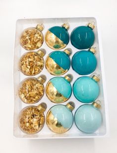 a white box filled with blue and gold christmas ornament ornaments on top of each other