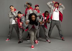 a group of young people standing next to each other in front of a gray background