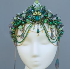 Enchanted Green Moonstone Tiara, a mesmerizing blend of emerald crystals, moonstones, and delicate beadwork, perfect for those who love fantasy and nature-inspired accessories.  This handmade crown features intricate wirework adorned with shimmering green beads, opalescent moonstones, and dainty chains, creating a whimsical and ethereal look. Ideal for weddings, cosplay, festivals, or bohemian-themed events, this tiara captures the essence of a mermaid queen or forest fairy. With its adjustable fit and comfortable design, it's the ultimate statement piece for your magical moments. Perfect for brides, cosplayers, or anyone seeking a unique touch of enchantment! Fantasy Festival Headpiece With Structured Crown, Moonstone Tiara, Fantasy Headband, Dark Mermaid Crown, Sabrina Style, Forest Crown, Mystical Festival Crown Headpiece, Viridescent Crown, Elven Crystal Crown