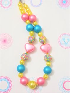 -  Pink hearts and sparkly beads adorable.  Pink, turquoise, yellow 20mm & 12mm beads with silver spacers. So cute.-  Your little girl or toddler will look like a Princess in this beautiful, fun, Chunky Bubblegum Necklace.-  This necklace would be the perfect dazzling addition for your little Princess outfit to wear for any special occasion.-  Necklace length 17"  20mm & 12mm beads Materials:  acrylic beads, resin beads, bead wire, crimp tubes, jump rings, stainless steel clasps**Custom Orders A Dog Necklace Collar, Toddler Jewelry, Princess Outfit, Bead Wire, Jewelry Girl, Bubblegum Necklace, Set Ideas, Necklace Collar, Bubblegum Beads