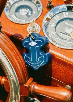 the steering wheel on a wooden boat with blue and white keychains hanging from it