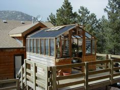 a wooden deck with a greenhouse built into it