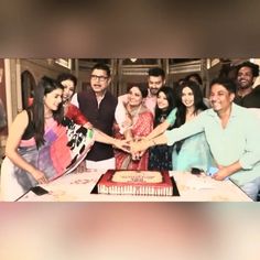 a group of people standing around a cake