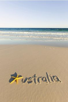 the word australia written in sand with a starfish on it's back end