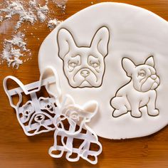 there are two cookie cutters on the table next to each other, one has an image of a dog