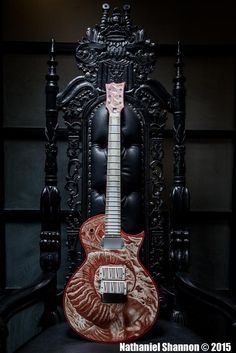 a red and white guitar sitting on top of a black chair