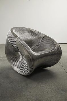 a large metal object sitting on top of a cement floor next to a white wall