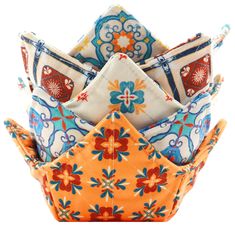 an orange, blue and white flowered cloth folded up in a pyramid shape with the top half rolled down