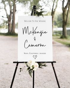 a welcome sign for a wedding with flowers and greenery on the easel outside