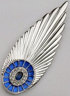 an image of a brooch with blue and white glass in the shape of wings