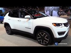 a white jeep is on display at an auto show