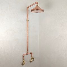 an old fashioned shower head and faucet with copper fittings on the wall