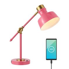 a pink desk lamp next to a smart phone