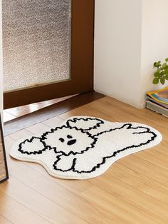 a dog rug on the floor in front of a door with a mirror and potted plant