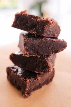 a stack of brownies sitting on top of a wooden table next to each other