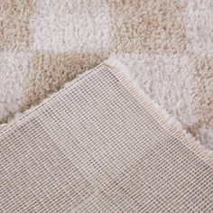 a close up of a rug on the floor with a piece of cloth next to it