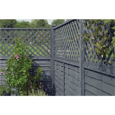 a wooden fence next to a green bush