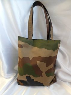 Medium size camo print unisex  book bag / Tote bag This striking tote / book bag features a 'camo' print in a premium canvas fabric. The camoflage print in khaki brown and black features on one side with the other side in a black waterproof canvas. The bag is lined in black cotton drill and has 3 interior pockets. Long handles attach to the bag in the same camo print. It has enough space to hold all essentials such as purse / wallet, phone, Ipad, bottle of water etc Also durable and functional a Military Style Rectangular Bag For Everyday Use, Military Style Satchel Bag For Daily Use, Military Style Shoulder Bag For Daily Use, Military Style Shoulder Bag For Everyday Use, Military Style Rectangular Outdoor Bag, Everyday Military Style Khaki Bag, Military Style Everyday Khaki Bag, Military Style Green Bag For Everyday Use, Green Military Style Bag For Everyday Use