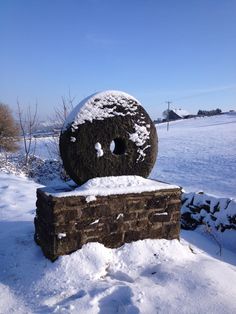 a snow covered stone wall with a hole in the middle