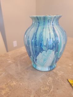 a blue and white vase sitting on top of a table next to a yellow marker