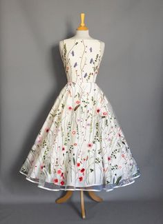 Whimsical Wedding Dress With Floral Embroidery, Whimsical Floral Embroidery Wedding Dress, Whimsical Floral Print Wedding Dress, Floral Embroidery Dress For Wedding Garden Party, Whimsical White Wedding Dresses, Floral Embroidered Dress For Wedding Garden Party, Floral Embroidered Dress For Garden Wedding, White Tea Length Dress For Garden Party, White Tea-length Dress For Garden Party