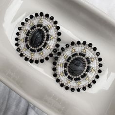 "These earrings are meticulously handcrafted with quality Japanese seed beads in black, gray, yellow & silver with silver opal rhinestone banding edged with black glass beads and silver seed beads on a silver nickel-free stud post. Earring backing is faux leather. Earrings measure ~2\" in length and width." Beaded Stud Earrings, Earrings Bead, Faux Leather Earrings, Gray Yellow, Bead Earrings, Leather Earrings, Black Glass, Earrings Jewelry, Jewelry Earrings Studs