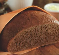 a loaf of bread sitting on top of a wooden cutting board next to a bowl