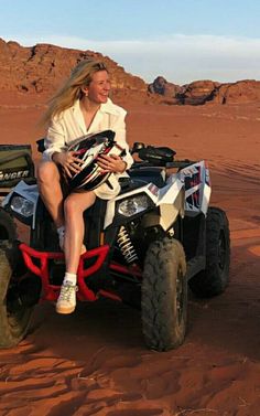 a woman is riding an atv in the desert