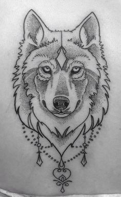 a wolf tattoo on the back of a woman's shoulder