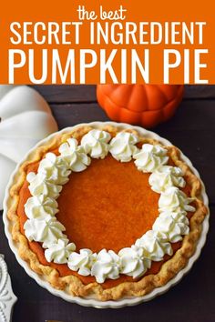 a pumpkin pie sitting on top of a table next to a white plate and silverware