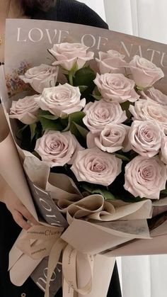 a woman holding a bouquet of pink roses