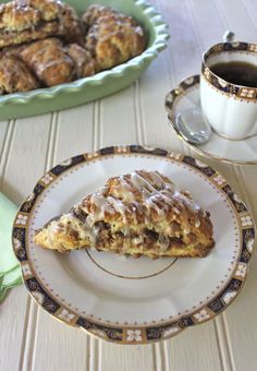 a plate with a pastry on it next to a cup of coffee and some other pastries