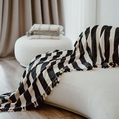 a black and white blanket laying on top of a bed