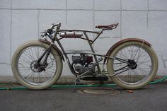 an old motorcycle is parked next to a wall