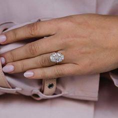 a close up of a person's hand with a diamond ring on their finger