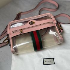 This Is The Authentic Gucci Vinyl Web Mini Ophidia Transparent Shoulder Bag Perfect In Pink. This Camera Style Cross Body Bag Is Crafted Of Transparent Vinyl With Light Pink Leather Trim. The Handbag Features A Matching Pink Leather Adjustable Shoulder Strap, A Front Zipper Pocket With The Signature Green And Red Web Stripe And Gold Hardware. The Bag Opens To A Transparent Interior With A D Ring And Has Room For All Of Your Daily Essentials With Sophisticated Style, Only From Gucci! Perfect Stad Gucci Pink Bag With Detachable Strap, Gucci Pink Crossbody Shoulder Bag, Gucci Pink Luxury Shoulder Bag, Gucci Luxury Pink Shoulder Bag, Pink Gucci Luxury Shoulder Bag, Pink Luxury Gucci Shoulder Bag, Trendy Gucci Shoulder Bag For Everyday Use, Gucci Pink Shoulder Bag For Everyday Use, Trendy Gucci Shoulder Bag With Detachable Strap